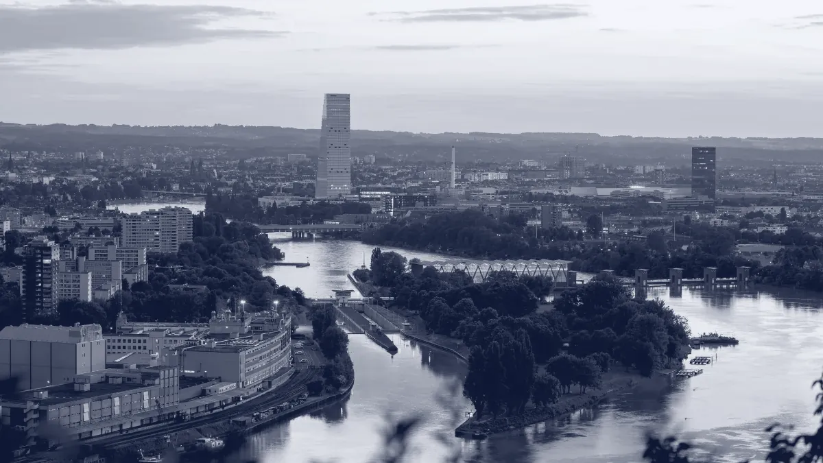 Basel in der Abenddämmerung, der Rhein zwischen der Stadt und dem Hafen